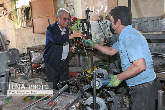 تقدیم شاخه گل در روز کارگر به کارگران معلول